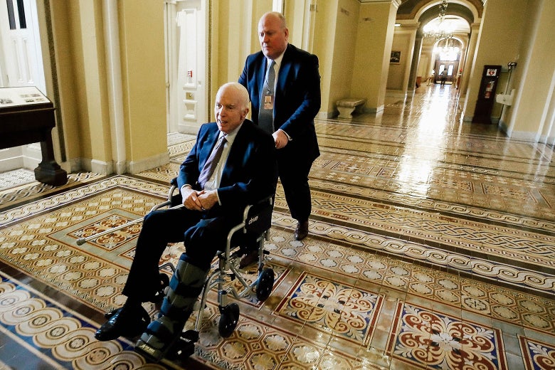 Arizona Sen. John McCain is pushed in a wheelchair between votes on Capitol Hill on Nov. 30 in Washington.
